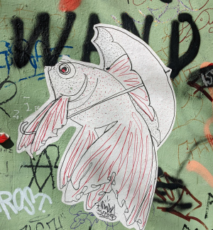 Fisch mit Regenschirm.  Pastt zu den Anglerwitzen, oder? Pasteup Streetart gesehen in Hamburg, lustiges Motiv.